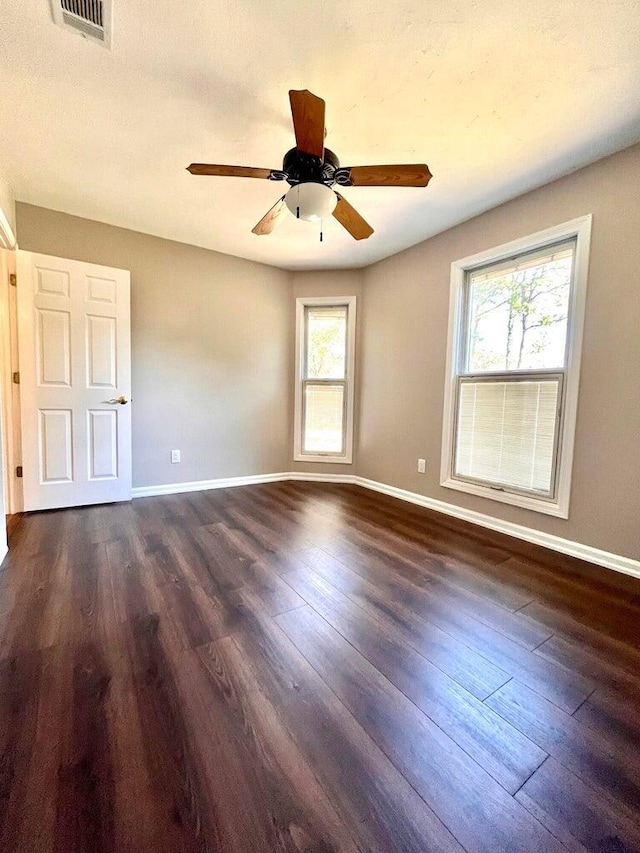 spare room with dark hardwood / wood-style flooring, plenty of natural light, and ceiling fan