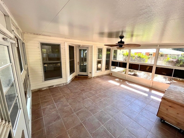 unfurnished sunroom with ceiling fan