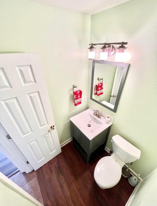 bathroom with hardwood / wood-style floors, vanity, and toilet