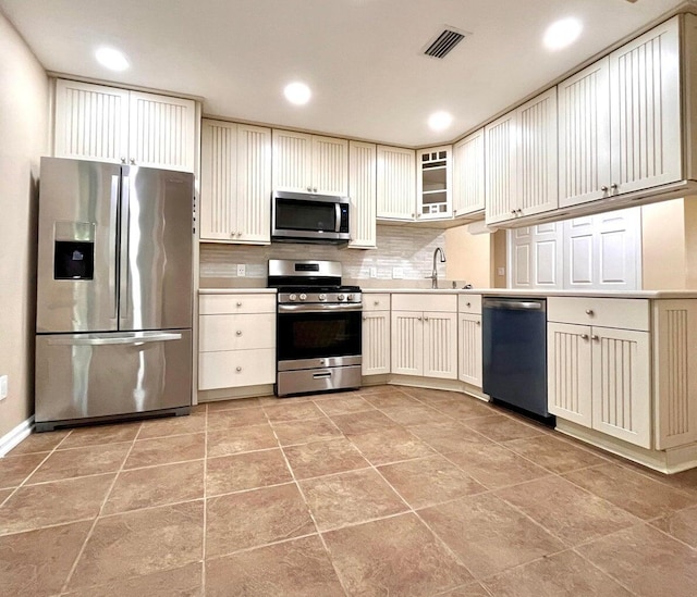 kitchen featuring light tile patterned floors, appliances with stainless steel finishes, and tasteful backsplash