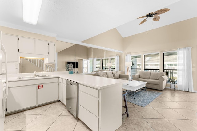 kitchen featuring white cabinets, sink, stainless steel dishwasher, ceiling fan, and kitchen peninsula