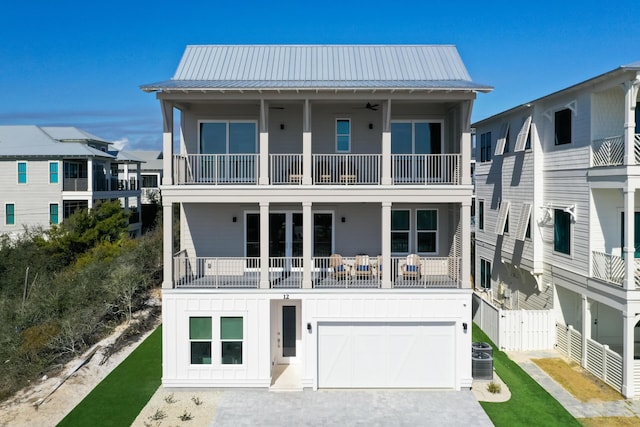 rear view of house with a garage, a balcony, and central AC