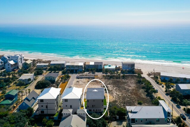 drone / aerial view featuring a water view and a beach view