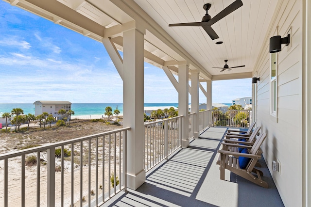 balcony featuring a water view and ceiling fan