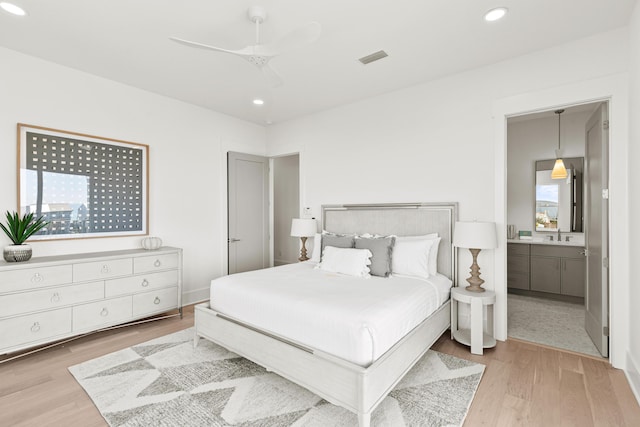 bedroom featuring ensuite bathroom, ceiling fan, and light hardwood / wood-style floors