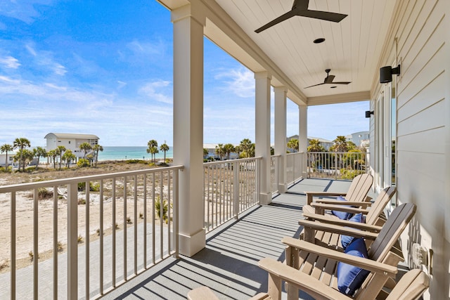 balcony with ceiling fan and a water view