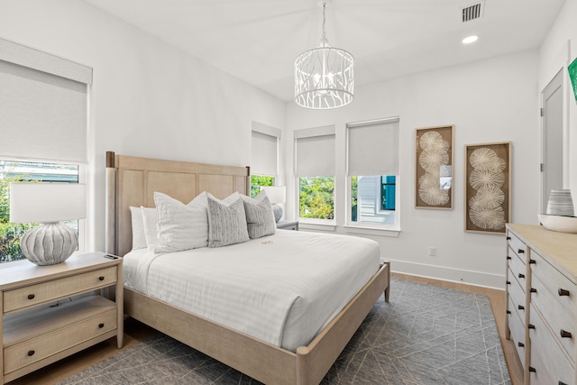 bedroom featuring an inviting chandelier and dark wood-type flooring