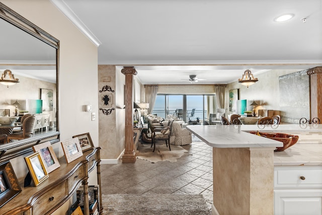 kitchen with white cabinets, decorative columns, ceiling fan, and crown molding