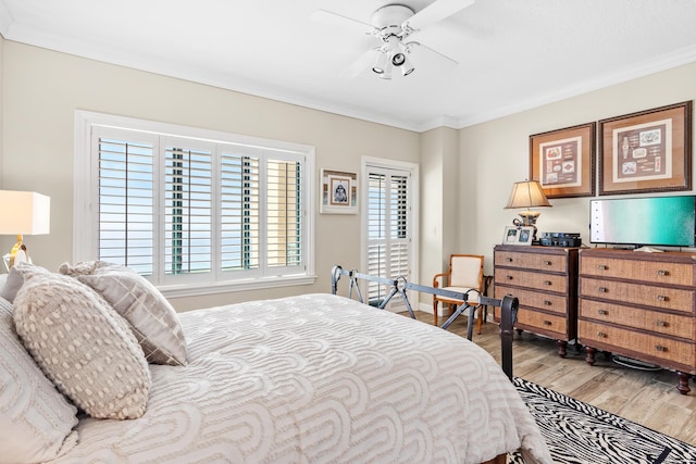 bedroom with light hardwood / wood-style flooring, ceiling fan, and crown molding