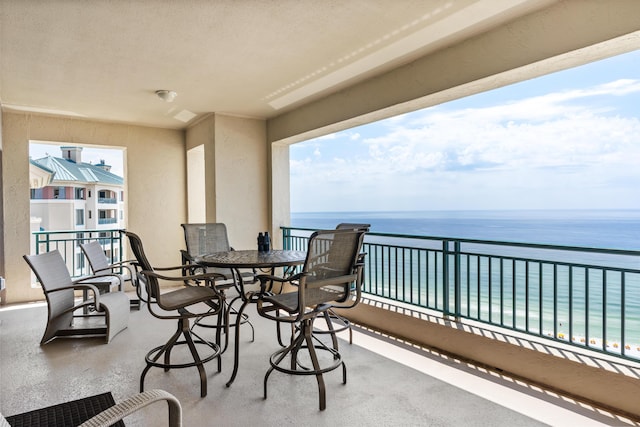 balcony featuring a view of the beach and a water view