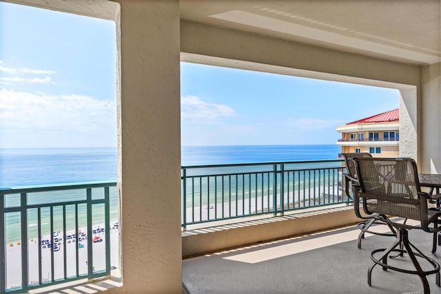 balcony with a water view and a beach view