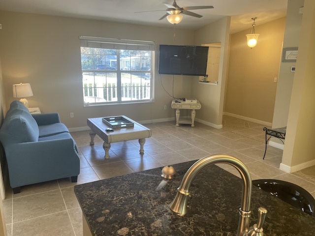 living room with ceiling fan, sink, and light tile patterned floors