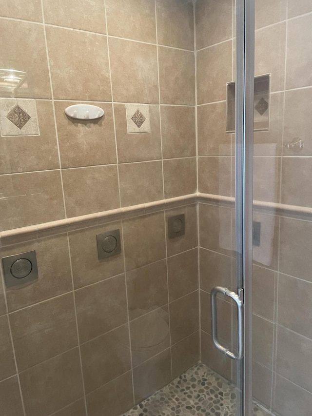 bathroom with a shower with door