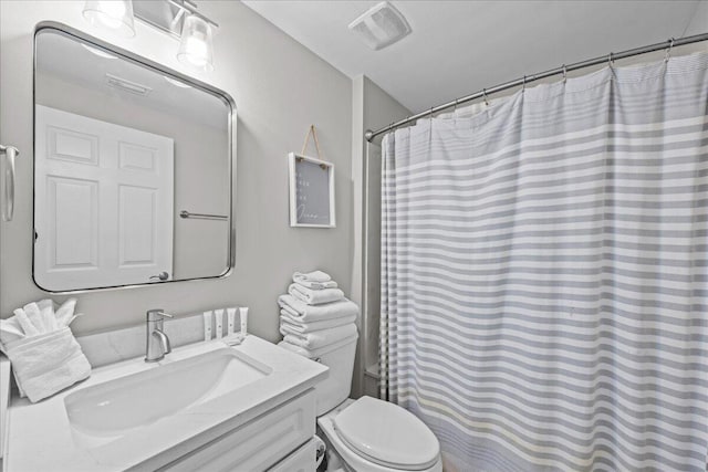 bathroom featuring walk in shower, vanity, and toilet