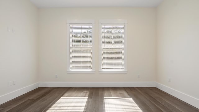 unfurnished room with dark wood-type flooring