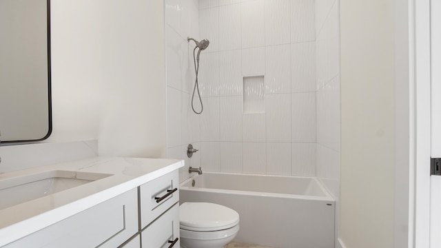 full bathroom with tiled shower / bath, vanity, and toilet