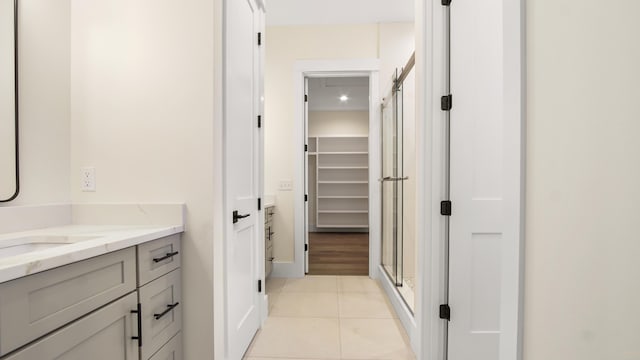 bathroom featuring tile patterned floors, vanity, and an enclosed shower