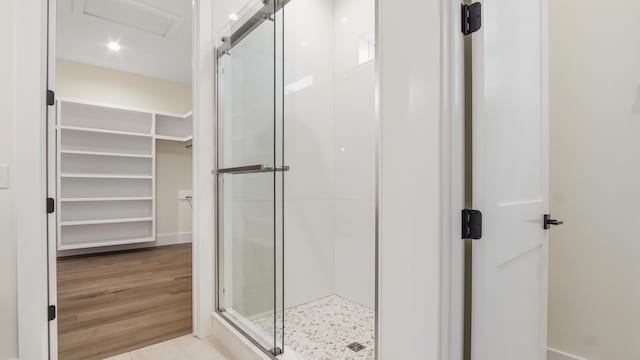 bathroom with hardwood / wood-style floors and an enclosed shower