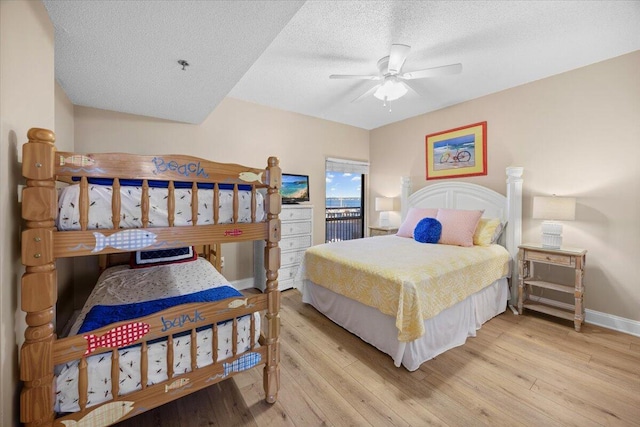 bedroom featuring ceiling fan, access to exterior, light wood-type flooring, and a textured ceiling