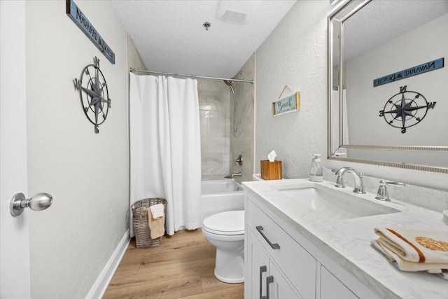 full bathroom featuring hardwood / wood-style flooring, vanity, toilet, and a textured ceiling