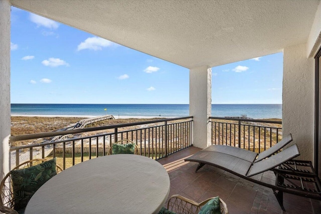 balcony featuring a water view and a view of the beach