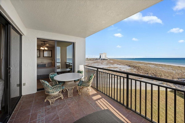 balcony featuring a view of the beach and a water view