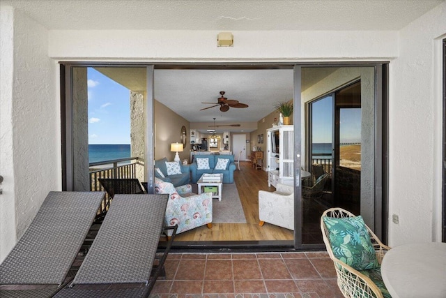 sunroom with a water view and ceiling fan