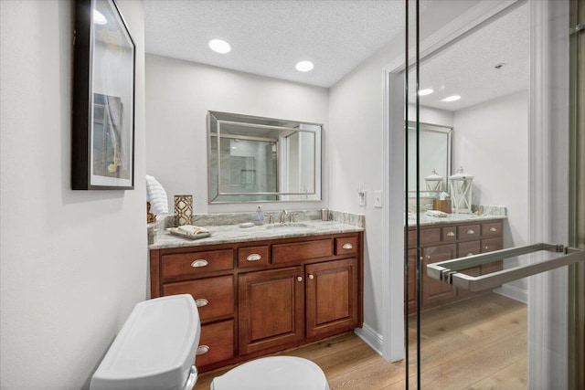 bathroom with vanity, a textured ceiling, and hardwood / wood-style flooring