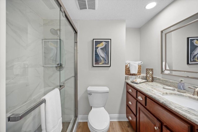 bathroom with toilet, vanity, an enclosed shower, and hardwood / wood-style flooring