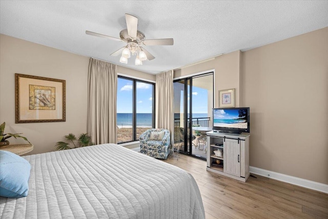 bedroom featuring access to exterior, a textured ceiling, light hardwood / wood-style floors, and ceiling fan