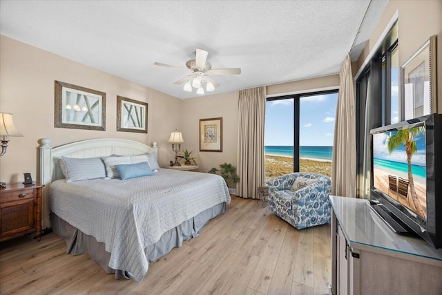 bedroom featuring a textured ceiling, light hardwood / wood-style floors, and ceiling fan