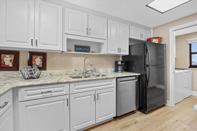 kitchen featuring sink, light hardwood / wood-style flooring, stainless steel dishwasher, white cabinetry, and washing machine and clothes dryer