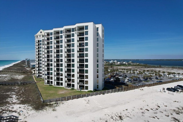 view of building exterior featuring a water view and a view of the beach