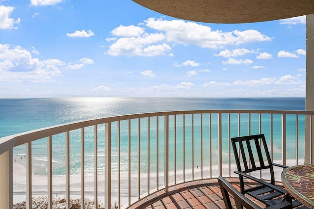 balcony with a water view and a view of the beach