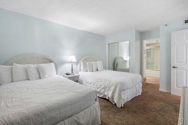 carpeted bedroom with ensuite bath and a closet