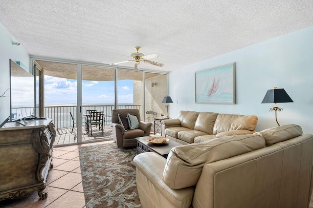 living room with a textured ceiling, a wall of windows, and ceiling fan