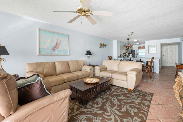 tiled living room with ceiling fan and a textured ceiling