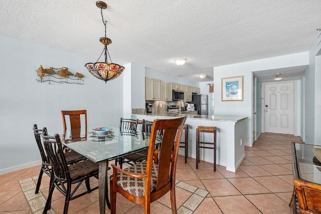 dining space with light tile patterned floors and a textured ceiling