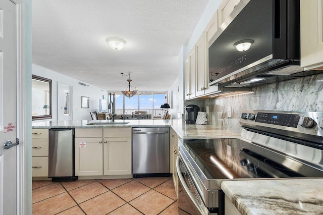 kitchen featuring sink, appliances with stainless steel finishes, tasteful backsplash, light tile patterned flooring, and light stone counters