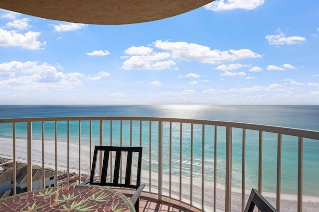 balcony with a water view and a beach view