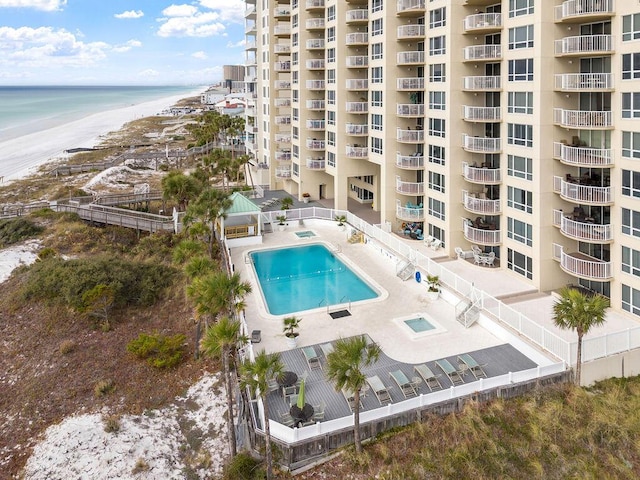 view of swimming pool with a beach view, a patio, and a water view