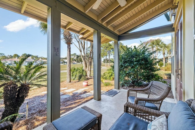 sunroom / solarium featuring lofted ceiling with beams