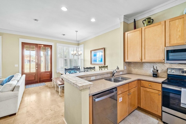 kitchen with sink, stainless steel appliances, kitchen peninsula, a chandelier, and decorative backsplash