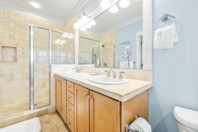 bathroom with vanity, toilet, a shower with door, and crown molding