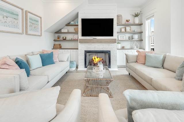 living room with a stone fireplace and ornamental molding