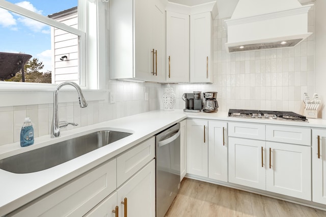 kitchen with premium range hood, backsplash, white cabinetry, and appliances with stainless steel finishes