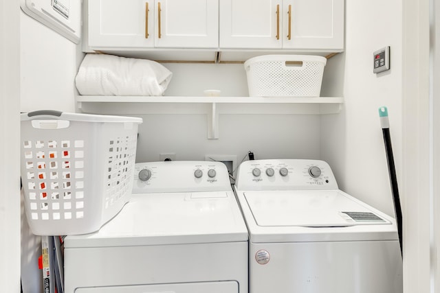 clothes washing area featuring cabinets and washing machine and dryer