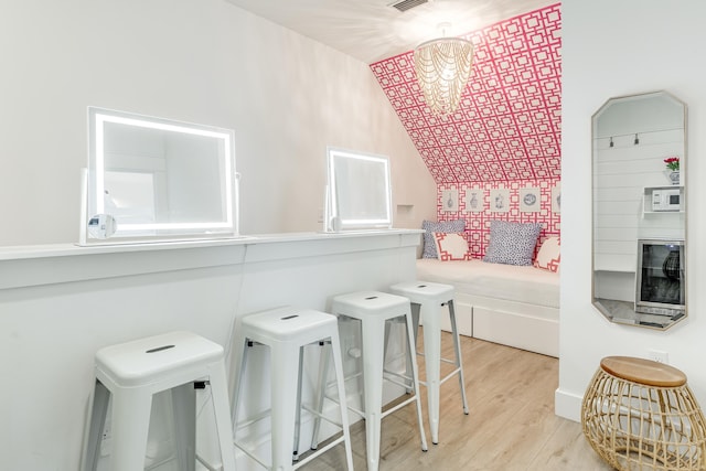 bathroom featuring hardwood / wood-style floors, vaulted ceiling, and a chandelier