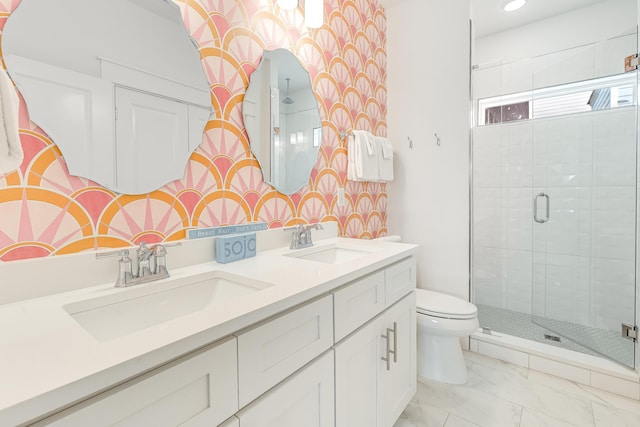 bathroom featuring vanity, a shower with shower door, and toilet