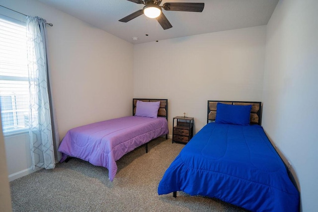 carpeted bedroom featuring ceiling fan and multiple windows